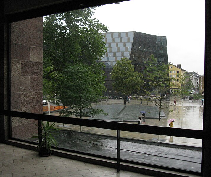 File:Platz der Alten Synagoge in Freiburg im Regen, Blick vom Kollegiengebäude II, hinter dem Synagogenbrunnen die Universitätsbibliothek.jpg