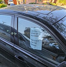 A parked car in Oakland with a sign asking would-be thieves not to smash the windows Please don't smash the windows sign.jpg