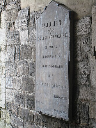 Sign on the church giving details (in French) of services. The sign is dated 25 March 1878 St. Julien's church sign.JPG