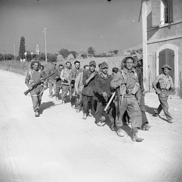 German prisoners being marched into captivity by men of the Queen's Royal Regiment, 56th Division, Montefiore area, 13 September 1944.