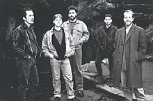 1990 yilda boshlangan. Chapdan o'ngga - Mayk Badjer, Toni Rassel, Denni Din, Pol Xemmings, Saymon Kuzins