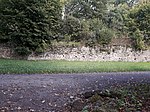 Trockenmauer Obstgarten von Belvedere mit einem Stück Rasen und angelegtem Wegstück