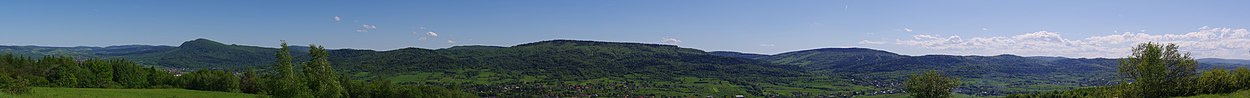 Panorama ze wzgórza na południe. Z lewej strony widać górę Cergowską, na środku Chyczki. W dole widoczne miejscowości (od lewej strony): Jasionka, Cergowa, Dukla, Nadole, Teodorówka, Iwla, Głojsce. W głębi widoczny stok w Chyrowej.
