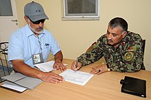 NATO official and Afghan colonel going through end-user documentation to transfer control of barracks to the Afghan army in 2009 120625-F-UZ487-014 (7567150378).jpg