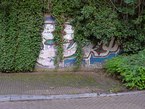 Amsterdam photo 2016 of street art, free download; close up of a brick graffiti wall along the sidewalk, overgrown by green ivy. Fons Heijnsbroek, street photography of The Netherlands in high resolution; free image