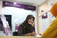 A seated bank teller in Indonesia, April 2011. Bank Muamalat.JPG