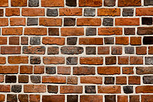 A wall constructed in glazed-headed Flemish bond with bricks of various shades and lengths. Brick wall close-up view.jpg