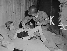 U.S. Army surgeon attends to a survivor in a sub-camp of Buchenwald concentration camp shortly after liberation. Buchenwald Penig Survivor J.W. Branch Chief Surgeon U.S. Army.jpg