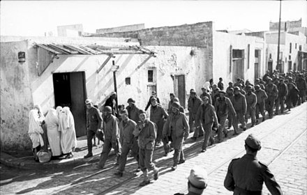 U.S. troops taken prisoner during the Battle of Kasserine Pass march through a Tunisian village