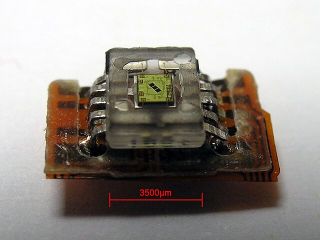 A photodetector salvaged from a CD-ROM drive. The photodetector contains three photodiodes, visible in the photo (in center).