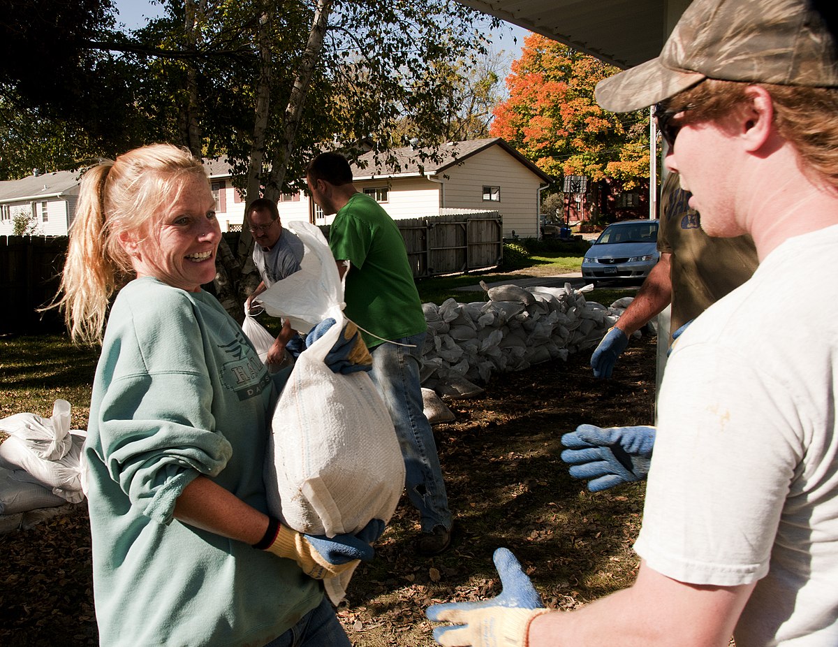 Volunteers help animals. Flood Control Sandbags. Help volunteering. Throwing Sandbags with Family.