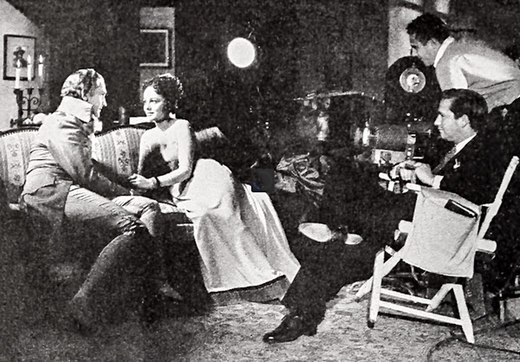 Mervyn LeRoy (seated right) directing March and De Havilland; behind LeRoy is cinematographer Tony Gaudio