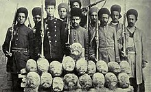 Heads of Turkmen chiefs stuffed with straw and brought to Tehran. These Turkmen, who were both feared and hated by the Iranians, were killed in battle with the Nationalists. They composed Muhammad Ali's principal fighting force in hist attempt to regain the throne. Heads of Turcoman chiefs stuffed with straw and brought to Teheran (cropped).jpg