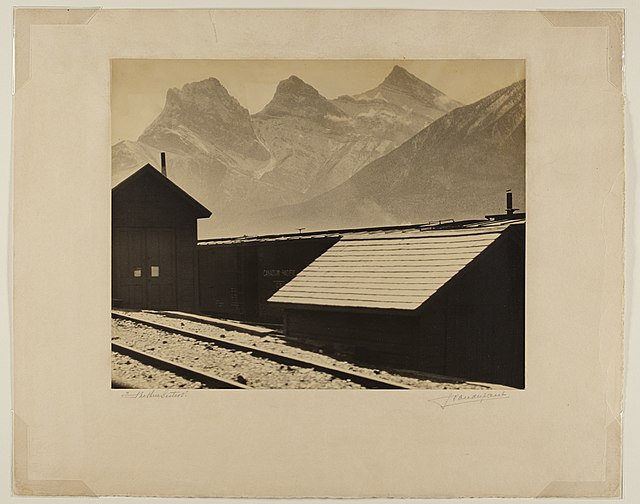 Black and white photograph of a house and mountains