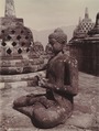 Buddha statue between stupas at Borobudur, circa 1925. Kurkdjian