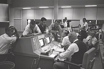 E. C. (em pé no centro) no Controle da Missão em Houston durante o voo Gemini 5 (21 de agosto de 1965)