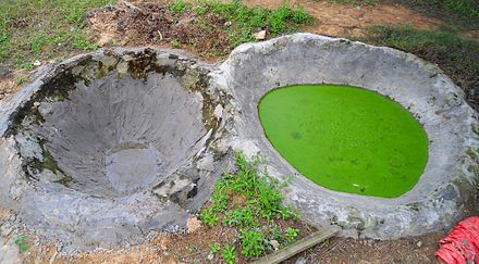 Concrete reservoirs, one new, and one containing cow manure mixed with water. This is common in rural Hainan Province, China.