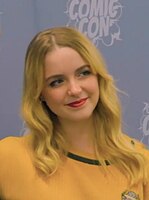 Mckenna Grace smiling towards her left in a yellow shirt at the 2023 German Comic Con in Dortmund