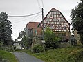 Wohnstallhaus, zwei Seitengebäude und Scheune sowie Stützmauer eines Vierseithofes