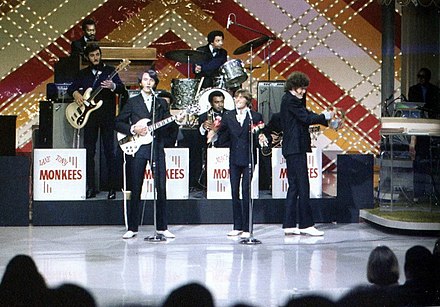 The Monkees (without Tork) performing on The Joey Bishop Show, backed by the Goodtimers, in 1969. The images of Jones and Dolenz were re-used for the cover art of the 1970 Monkees album Changes.