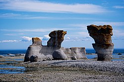 Standing rocks next to water