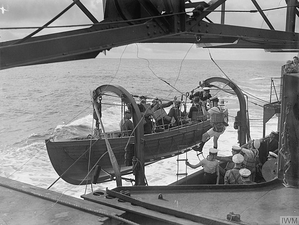 A Montagu whaler being manned with an armed boarding party going to check a neutral vessel stopped at sea. October 1941