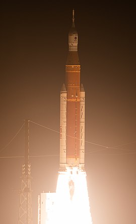 NASA's Space Launch System launching Artemis I with a bright trail of flame.