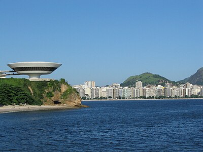 A view from Rio de Janeiro over the bay to Niterói in full sunlight. On the left, the Niterói Contemporary Art Museum (MAC - Museu de Arte Contemporânea de Niterói) designed by Oscar Niemeyer