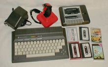 Commodore Plus/4 with accessories. Clockwise from top left: power supply, joystick, 1531 tape recorder with tapes Plus4 komplett.jpg