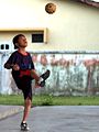 Seorang anak bermain dengan bola takraw