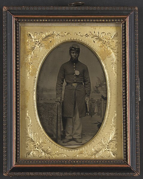 File:Sergeant Tom Strawn of Company B, 3rd U.S. Colored Troops USCT Heavy Artillery Regiment, with revolver in front of painted backdrop showing balustrade and landscape.jpg
