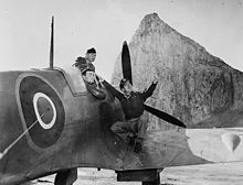 The IFF antenna can be seen on the left of this photo, meeting the fuselage in the RAF roundel. The lengthy antennas, which had to be placed on both sides of the fuselage, slowed the Spitfire by about 2 miles per hour (3.2 km/h). Rock of Gibraltar in background. Spitfire Gibraltar 1942.jpg