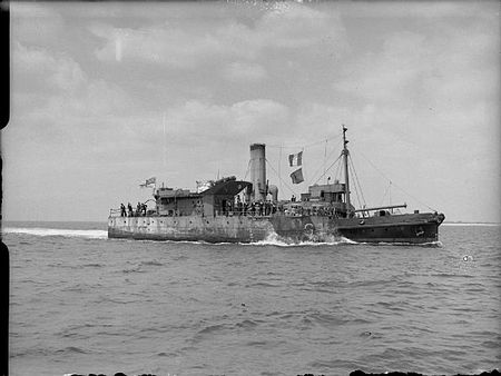 The stern of Porcupine, later commissioned as HMS Pine, being towed into Portsmouth The Royal Navy during the Second World War A17603.jpg