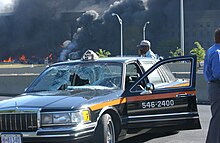 A Lincoln Town Car taxicab was hit by a lightpole as American Airlines Flight 77 passed over Washington Boulevard and crashed into the Pentagon. The pentagon in flames (background) moments after a hijacked jetliner crashed into building at approximately 0930 010911-M-CI426-018.jpg