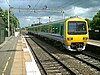 An electric multiple unit pulling into Tile Hill station on the West Coast Main Line in Coventry, England.