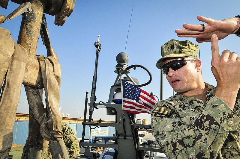 File:U.S. Navy Chief Engineman Sam Pona signals hoisting strap positions to a crane as it prepares to lift a coastal command boat from a pier and into the water at Naval Support Activity Bahrain Feb. 10, 2014 140210-N-IZ292-068.jpg