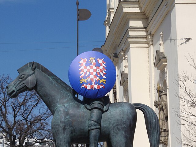 Statue in front of a building, seen from the side