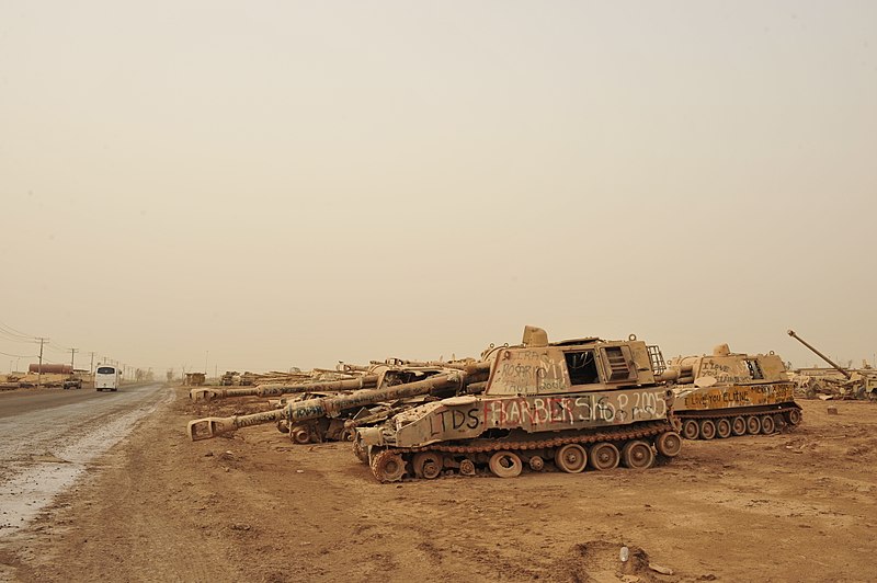 File:Broken-down howitzers line a street at Camp Taji.jpg