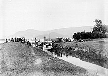 COLLECTIE TROPENMUSEUM Sloepen worden langs een brug en door een kanaal getrokken bij Pangoeroeran TMnr 10018534.jpg