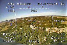 A typical analog FPV video feed with an on-screen display (OSD) readout showing navigational data. FPV OSD.png