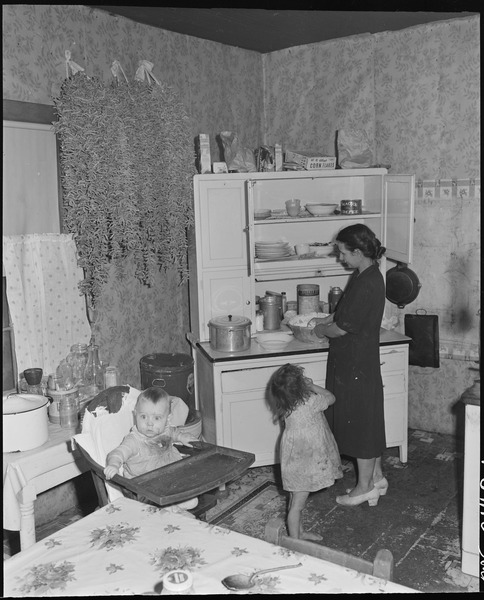 File:Mrs. George Hoskins, wife of a miner, and two of her ten children in the kitchen of their three room house. Coleman... - NARA - 541132.tif