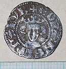 dull, silver coin with a king's head in the centre wearing a crown