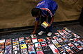 A street vendor packing up his display of counterfeit cds after being photographed.