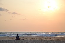 In this image, this meditator could be undertaking xx meditation, as using the external cue of the waves crashing on the beach to focus thoughts.