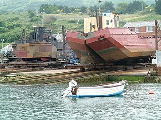 Two slipways at Portland Harbour - one holding a landing craft and the other a split dump barge (on right). Slipway at portland.JPG