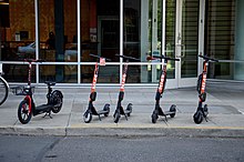 Ride-share scooters from two different providers parked on a sidewalk in Northwest Portland Spin and Razor rental electric scooters in Portland, Oregon (2019).jpg