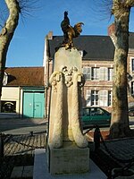 The garlanded war memorial at St Riquier