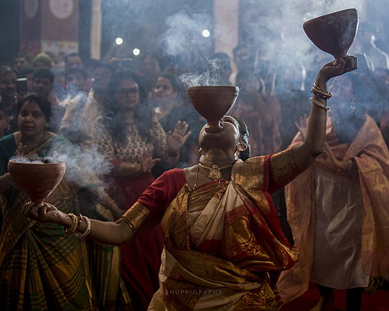 Women performing traditional Dhunachi ritualized dance worship by Bhuppigraphy