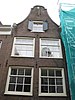 Huis met gevel onder klokvormige top met rollagen