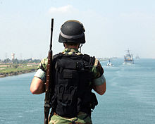 A border guard soldier guarding the waterway of the Suez canal. US Navy 050909-N-2259V-001 Master-at-Arms 2nd Class Robert Pallozzi stands a flight deck security patrol as the amphibious assault ship USS Tarawa (LHA 1) transits through the Suez Canal.jpg